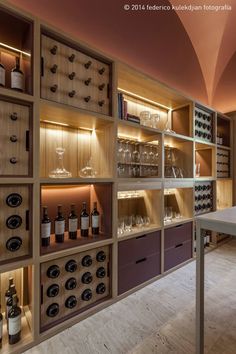 a wine cellar filled with lots of bottles and glasses