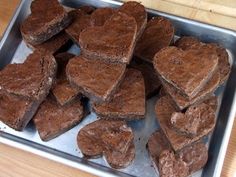 heart shaped brownies in a metal pan on a wooden table