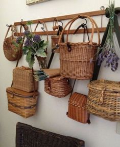 wicker baskets hanging on a wall with flowers and plants in the basket holders below