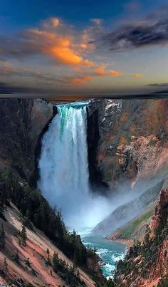 the sun is setting over a large waterfall