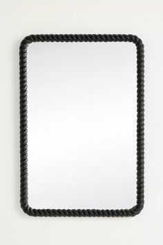 a square mirror with black rope around it