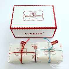 two wrapped cookies are sitting in front of a box