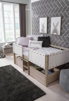 a white day bed sitting in a bedroom next to a gray and white rug on top of a hard wood floor