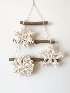 three snowflakes are hanging on the wall, one is made out of wood