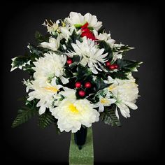 a vase filled with white flowers and greenery