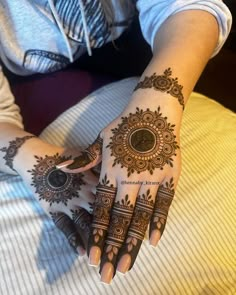 a woman's hand with henna tattoos on it