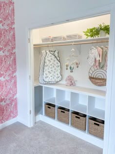 the closet is full of baby's clothes and other items in baskets on shelves