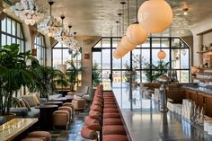 a long bar with lots of chairs and tables in front of large windows that look out onto the ocean