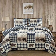 a bed covered in a checkered comforter and pillows with bears on the cover