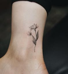 a small flower tattoo on the ankle