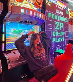 a woman sitting in front of a video game machine