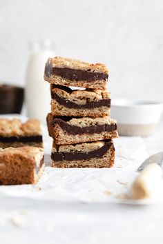 chocolate and peanut butter bars stacked on top of each other with milk in the background