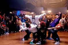 a group of people standing on top of a wooden floor in front of a crowd