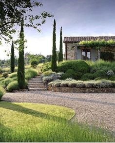 a stone house surrounded by lush green grass and trees in front of it, with steps leading up to the entrance