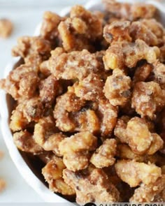 a white bowl filled with nuts on top of a table