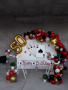 a casino themed birthday party with balloons and streamers on the wall, including an 80th birthday sign