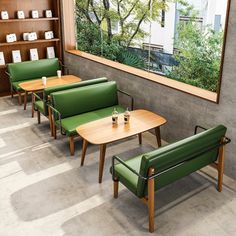 a row of green chairs sitting next to each other in front of a wooden table