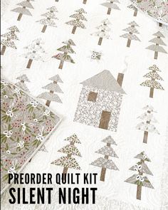 a white quilt with trees on it and the words, preorder quilt kit silent night