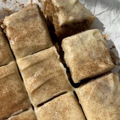 several pieces of cake sitting on top of a piece of wax paper with cinnamon sprinkles