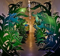 an art installation with green leaves on the walls