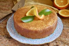 a cake on a plate with oranges and a knife in the backgroud