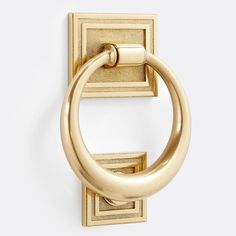 an image of a gold door handle on a white wall with the letter o in it