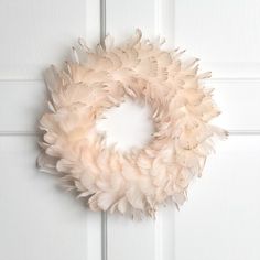 a white door with a feather wreath hanging on it