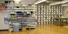 an empty room with many shelves and bins on the wall, in front of a wooden floor