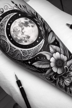 a black and white photo of a full moon with flowers on it's arm