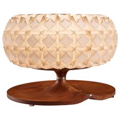 a wooden table with a lamp on it's base and an intricately designed surface