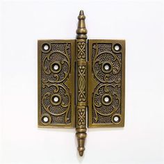 an antique brass plated door hinge with decorative designs on the front and sides