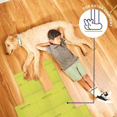 a young boy laying on the floor next to a dog and measuring it with a tape measure