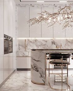 an elegant kitchen with marble counter tops and white walls, along with a chandelier hanging from the ceiling