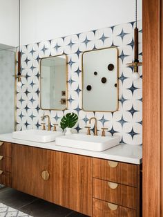 a bathroom with two sinks and mirrors on the wall above them is decorated in black and white tiles