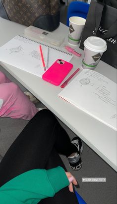 a woman sitting at a desk with her legs crossed and writing on a notepad