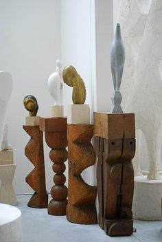 several wooden sculptures sitting on top of a white floor