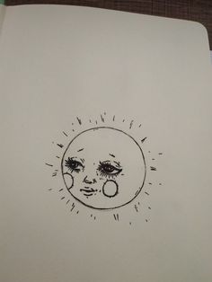 a drawing of a sun and a face on a piece of paper with writing underneath it