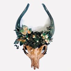 an animal skull with flowers on it's head is seen against a white background