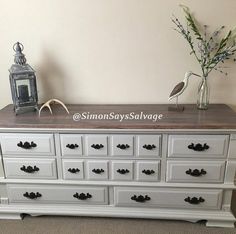 a white dresser with drawers and flowers on top