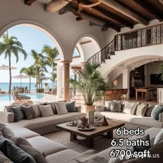 a living room filled with lots of furniture next to an ocean side pool and palm trees