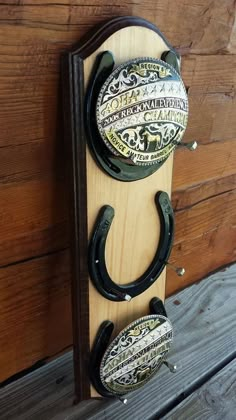 two horseshoes mounted to the side of a wooden wall hanging on a wood board