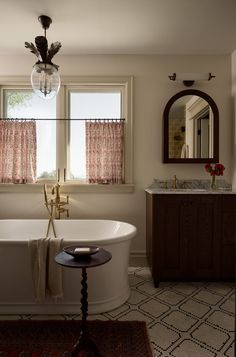 a bath tub sitting next to a window in a bathroom