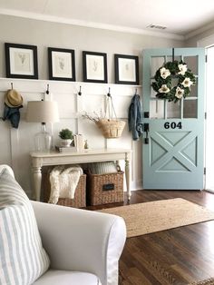 a living room with white furniture and pictures on the wall above it, including a blue door