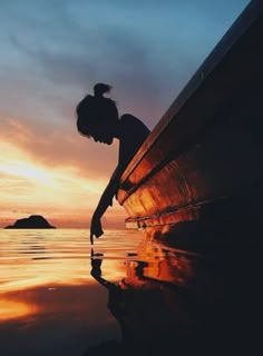 a person leaning on the edge of a boat at sunset with a quote above it