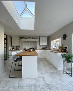 a kitchen with a skylight above the counter top and chairs on the floor next to it