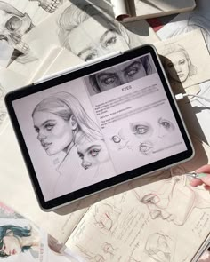 a person is holding up a tablet with drawings on it and the screen has an image of a woman's face