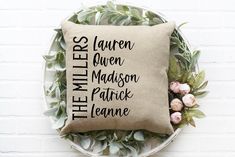 a pillow that has the names of different people on it and some flowers around it