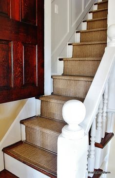 a set of stairs leading up to a wooden door and white railing with wood paneling