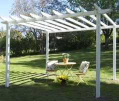 a table and chairs under a white pergolan