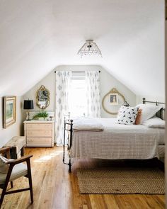 a bedroom with white walls and wooden floors